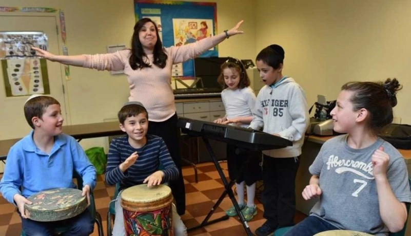 A group of children with special needs engaged in a music therapy session, playing instruments together
