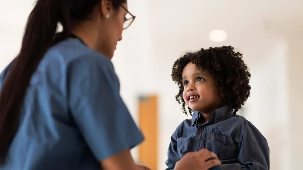 Image of a compassionate doctor interacting with a young boy, showcasing the impact of early intervention