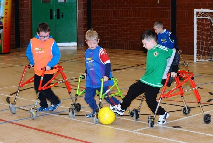Image of kids with mobility aids actively participating and enjoying a game of football