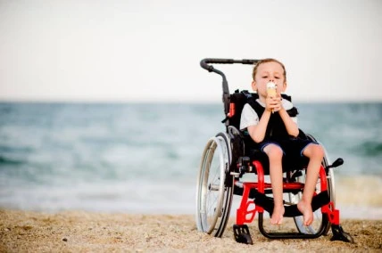 A child in a wheelchair happily indulging in a nutritious ice cream treat, highlighting the importance of nutrition.