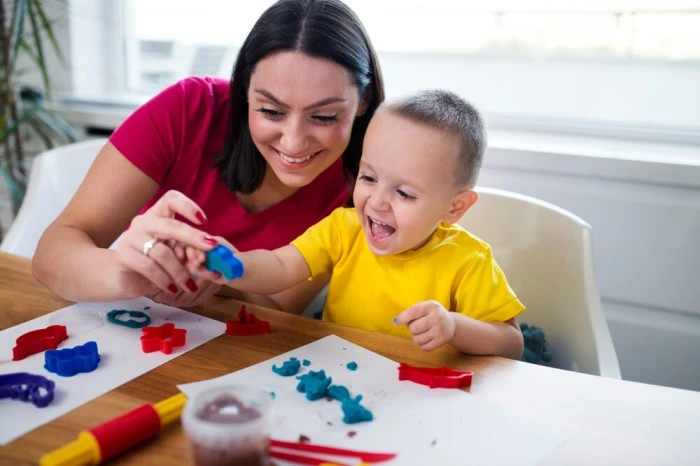 Mom and baby engaging in sensory play with playdough to support sensory processing disorder