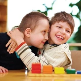 Two kids hugging in class, highlighting the impact of the Individualized Education Plan (IEP) on fostering inclusivity.